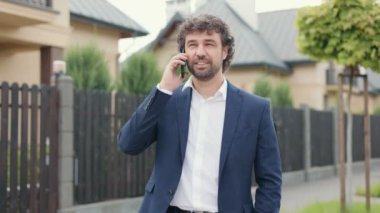 Kafkas asıllı profesyonel bir erkeğin portresi şehirde duruyor ve akıllı telefondan konuşuyor. Yakışıklı bir iş adamı sokakta cep telefonuyla konuşuyor. İş konsepti