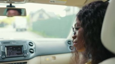 Arabada oturan adam ve kadının arka görüntüsü. Adam araba sürüyor ve karısı yolculuk sırasında ona bakıyor. Arabada oturan genç bir kadın. Otomobil iç konsepti