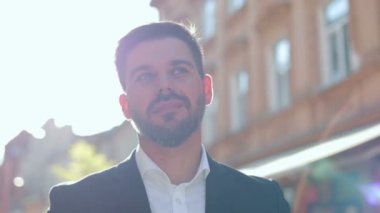 Yakışıklı genç girişimci şehirde sokakta tek başına dikilirken kameraya bakıyor. Kafkas erkek yöneticisinin yakın portresi. İş adamı, akıllı görünüş.