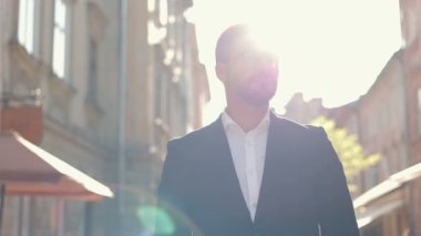 Yakışıklı genç girişimci şehirde sokakta tek başına dikilirken kameraya bakıyor. Kafkas erkek yöneticisinin yakın portresi. İş adamı, akıllı görünüş.