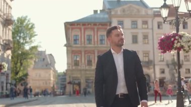 Rahatlamış hissediyorum. Seçkin deneyimli, beyaz takım elbiseli bir işadamı, molasını harcarken sokakta yürüyor ve dikkatlice bakıyor.