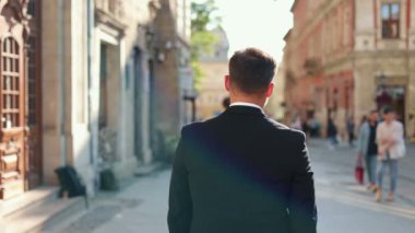 Beyaz tenli genç adamın iş tarzında şehrin sokaklarında sakince yürürken görüntüsü. İş konsepti. Kapat.