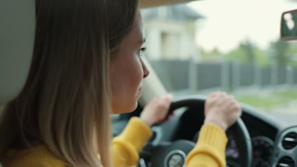 严重的年轻高加索女人开车在路上看着车屏 感觉很集中 靠近点 — 图库视频影像