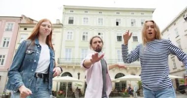 Üç kadın ve erkek, şehir caddesinde dans ederek eğleniyorlar. Mutlu erkek ve kadınlar hayattan zevk alıyor, gülüyor ve dışarıda takılıyor. Gençlik, eğlence, gençlik konsepti.