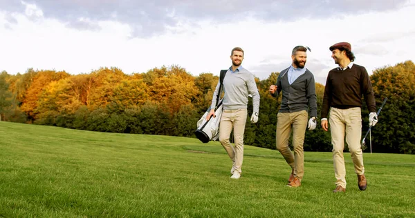 Attractive Male Friends Walking Clubs Bag Golf Pitch Talking Laughing — Foto Stock