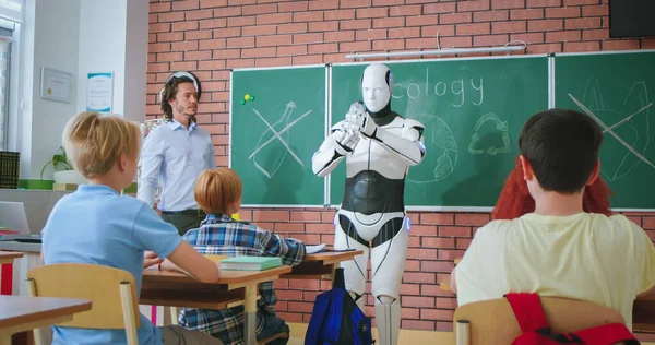 自动人形机器人站在教室前与学生和教学回收 男教师 循环利用概念 在学校学习生态学 学习技术 Android教师 — 图库照片