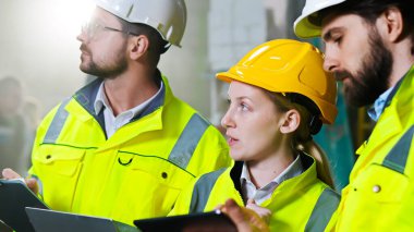 İnşaat alanındaki beyaz inşaat ekibini kapatın ve tabletle iş konuşun..