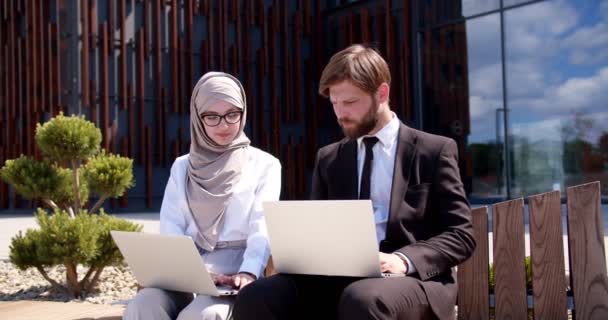 Kaukázusi Üzletember Arab Üzletasszony Hidzsábban Utcán Közel Irodaházhoz Laptop Számítógépeken — Stock videók