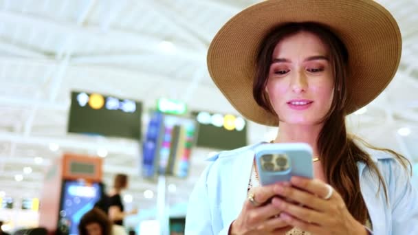 Χαρούμενη Εστιασμένη Και Γοητευτική Καυκάσια Γυναίκα Κάθεται Αεροδρόμιο Χρησιμοποιώντας Smartphone — Αρχείο Βίντεο