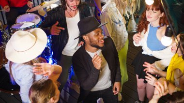 Genç Afrikalı Amerikalı bir adam çatıdaki bir partide dans edip arkadaşlarıyla eğleniyor. Arkadaşlarla eğlenmek, çatı partisi müziği dinlemek, hafta sonu buluşmasını kutlamak..