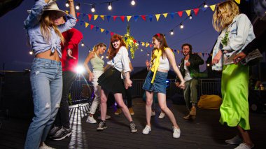 Çatıdaki bir partide dans eden genç beyaz kadınlar. Arkadaşlarla eğlenmek, çatı partisi müziği dinlemek, hafta sonu buluşmasını kutlamak..