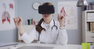 Beyaz önlüklü ve VR kulaklıklı beyaz kadın doktor dolapta oturmuş ellerini havada kaydırıyor ve soyuyorlar. Sanal gerçeklik kavramı. Sağlık sigortası fütüristik. Doktor gelecekte çalışıyor..