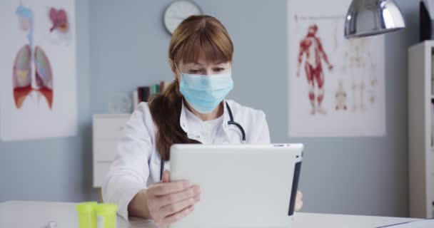 Médico Muito Feliz Trabalhando Tocando Dispositivo Enquanto Sentado Mesa Armário — Vídeo de Stock