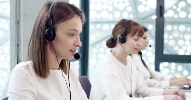 在现代呼叫中心办公室工作的吸引人的专注的高加索女性形象 作为客户支持代表 在线使用耳机和膝上型计算机的专业女工 — 图库视频影像