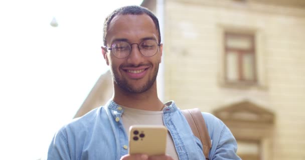 Sırt Çantalı Gülümseyen Cep Telefonuna Mesaj Atan Mesaj Okuyan Genç — Stok video