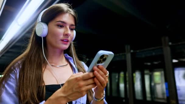 Tramvay Istasyonunda Beklerken Cep Telefonu Kullanan Kablosuz Kulaklıkla Müzik Çalan — Stok video