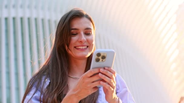 ハッピー美しい少女若いビジネス女性は 携帯電話 スマートフォン画面 ネットでチャット 笑顔でオンラインでチャット ガジェットデバイスを使用してソーシャルメディアでメッセージに答えます — ストック動画