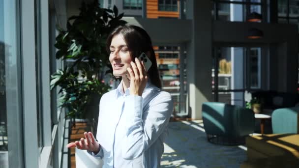 Atrakcyjna Bizneswoman Stojąca Przy Oknie Nowoczesnym Biurze Rozmawiająca Przez Smartfona — Wideo stockowe