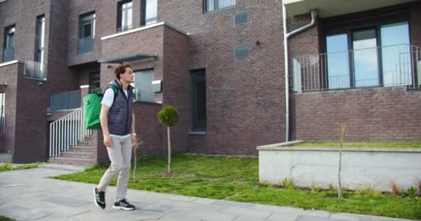 Вид Сбоку Молодого Мужчины Курьера Большим Термальным Рюкзаком Идущего Улице — стоковое видео
