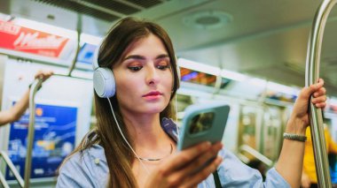 Kulaklıkla müzik dinleyen ve metro vagonunda akıllı telefon tutan genç bir kız yeraltında kablosuz internet bağlantısı kullanıyor. Cep telefonlu kurye ile internet üzerinden kadın sohbeti Metro 'da video izleme