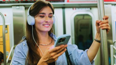 Cep telefonlu kuryeyle sohbet eden bir kadın metroda video izliyor. Kulaklıkla müzik dinleyen ve metro vagonunda akıllı telefon tutan genç kız yeraltında kablosuz internet bağlantısı kullan.