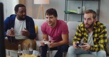 Neşeli, genç, melez erkekler evlerinde oturup konsolda oyun oynuyorlar, sohbet ediyorlar ve içkilerle eğleniyorlar. Erkekler televizyon karşısında bira ile video oyunu oynarlar. Hobi konsepti