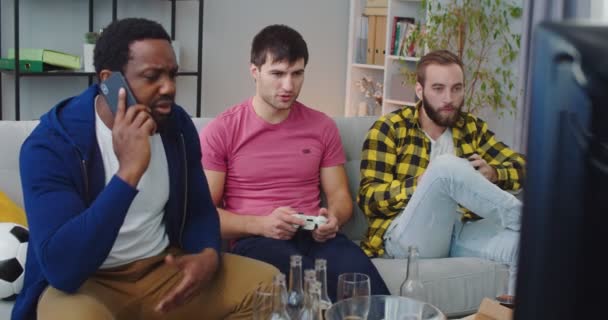 Hombres Carreras Mixtas Amigos Pasando Rato Juntos Casa Sentados Sofá — Vídeo de stock