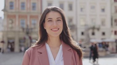 Uzun saçlı güzel genç kızın portresi ılık bahar şehrinin caddesinde sabahları günlük kıyafetlerle dikiliyordu. Mutlu kadın portresi.