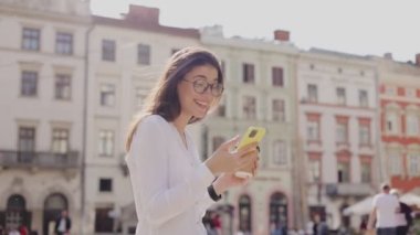 Kafkas bir kadının portresi, uzun siyah saçlı ve gün boyunca şehir sokaklarında gezen, akıllı telefona bakan ve elini arkadaşlarına sallayan. Teknoloji ve güzellik kavramı