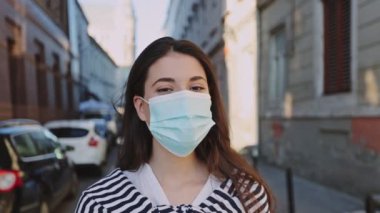 Güneş batarken park yerinde koruyucu yüz maskesi takan esmer beyaz kızın portresi. Koronavirüs salgını COVID-19, salgın ve sağlık konsepti