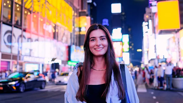 美国时代广场上美丽迷人的白种人快乐女人的画像 微笑着看着镜头 相当快乐的成年女孩喜欢旅行 旅游概念 图库照片