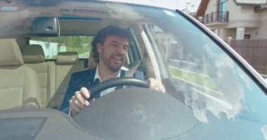 Açık yolda özgürlük. Ön koltukta rahatlayan, arabasını süren ve müzik dinlerken şarkılar söylerken zevkle gülümseyen neşeli genç adamın ön görüntüsü. İnsanlar ve ulaşım kavramı