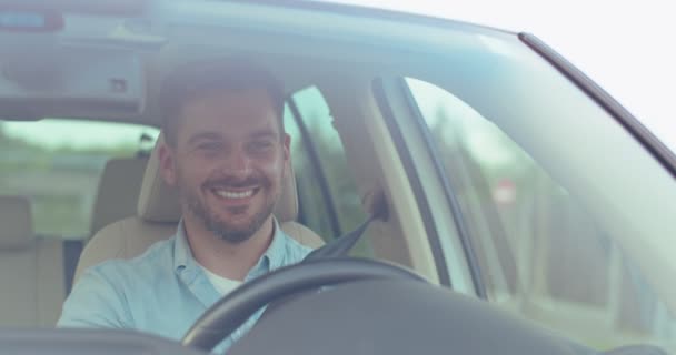 Jovem Homem Caucasiano Agradável Viajando Carro Pela Cidade Dia Sorrindo — Vídeo de Stock