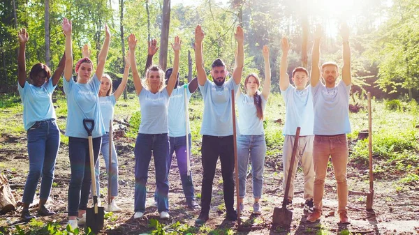 stock image Diversededicated eco volunteers concerned about the global problem of pollution. The eco activists, conservationists raising their hands to the sky. Save our planet concept