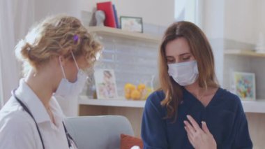 Vücut ısısı ölçümü. Lazer temassız termometre. Koronavirüs sırasında hasta bir bayanın vücut ısısını ölçen kadın doktor.