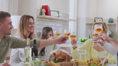 Mutlu arkadaşlar birlikte yemek yer ve evde kadeh tokuştururlar. İlişkiler ve tatil kavramı