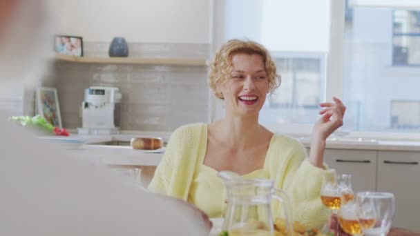 식탁에서 저녁을 행복한 금발의 Curly 감정적으로 클링킹 — 비디오