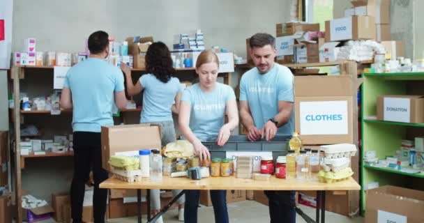 Young Man Woman Blue Uniform Packing Actively Donation Boxes While — Stock Video