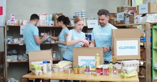 Pár Bělošských Dobrovolníků Balí Třídí Darované Jídlo Zatímco Další Pár — Stock video