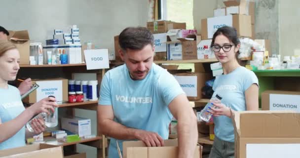 Team Van Liefdadigheidsfonds Werknemers Vullen Donatie Kartonnen Dozen Met Voedsel — Stockvideo