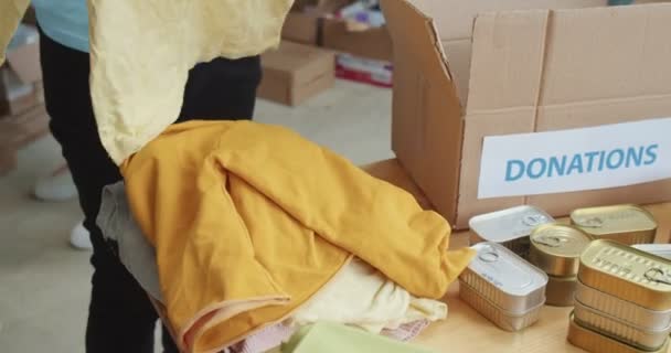 Закрыть Группу Волонтеров Упаковывающих Детскую Одежду Картонные Коробки Пожертвования Молодые — стоковое видео