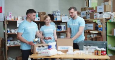 Gönüllülerden oluşan ekip çalışması karton paketleri ilaçlarla doldururken bir yandan da hayır kurumuna yardım ediyor. İnsan kavramı, samimi yardım ve sağlık hizmetleri.