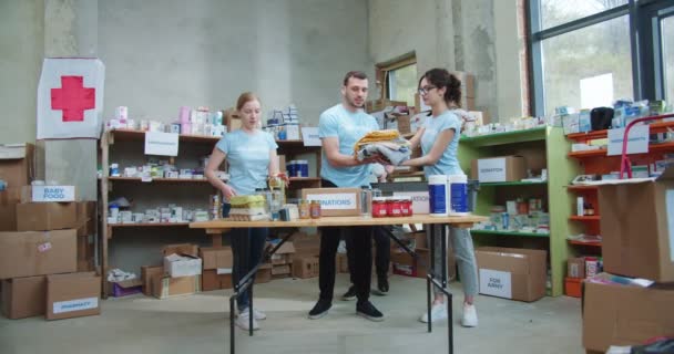 在红十字会慈善基金会工作的高加索人的团队合作 社会中心志愿者为有需要的人提供衣物和食物捐赠盒 — 图库视频影像