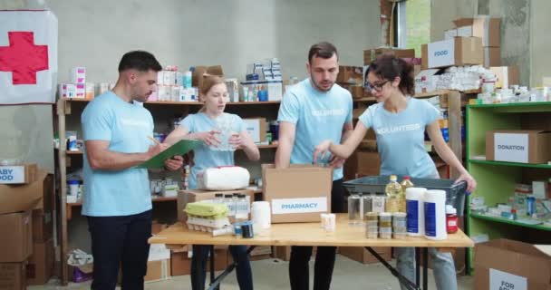 Junge Freiwillige Machen Notizen Klemmbrett Während Kollegen Die Apothekenbox Spendenlager — Stockvideo