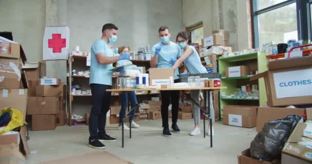 Grupo Voluntários Máscara Protetora Luvas Borracha Que Trabalham Centro Comunitário — Vídeo de Stock