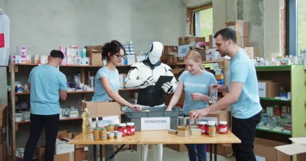 Автоматический Робот Делает Заметки Планшете Группа Людей Упаковывает Коробки Пожертвований — стоковое видео