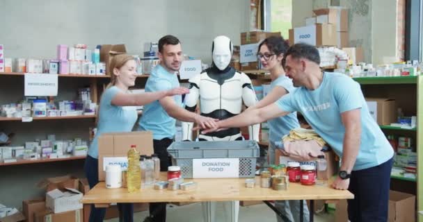 Mladí Kavkazští Dobrovolníci Humanoidní Robot Spojují Ruce Při Práci Skladišti — Stock video