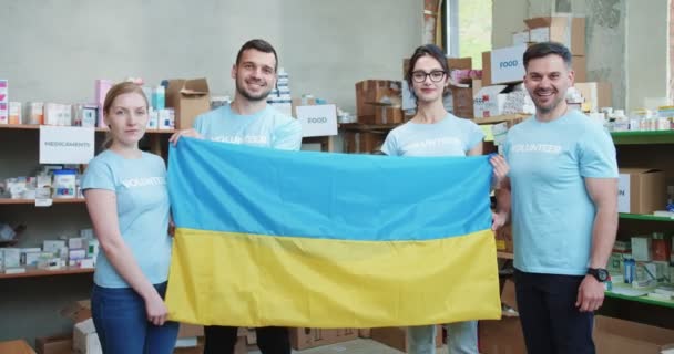 Grupo Caucasiano Pessoas Com Roupas Voluntários Azuis Segurando Bandeira Nacional — Vídeo de Stock
