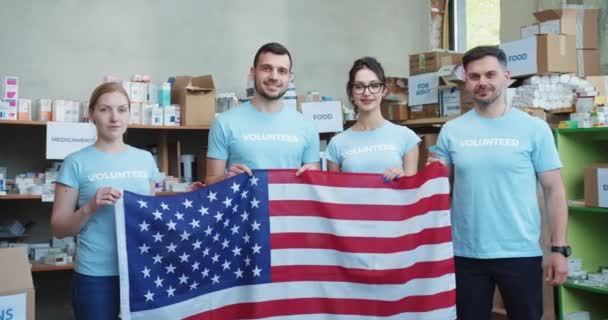 Amerykański Zespół Wolontariuszy Stojący Magazynie Centrum Dawstwa Trzymający Flagę Usa — Wideo stockowe