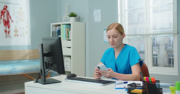 Pretty Young Female Nurse Using Smartphone While Sitting Table Doctors — Stock Video
